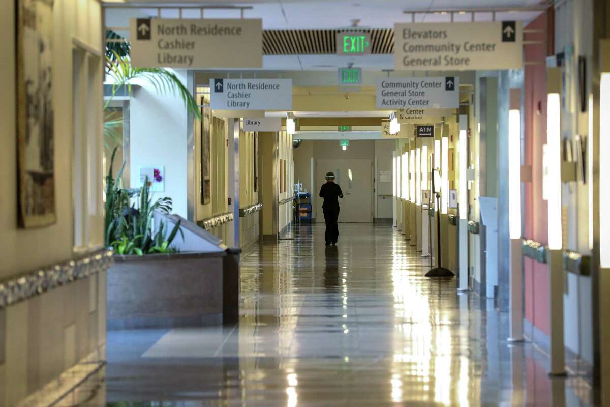 A member of the Laguna Honda Hospital’s staff walks down the hallway in July, 2022. The beleaguered San Francisco nursing home has asked regulators to indefinitely extend a moratorium on transferring out its fragile patients under federal orders.