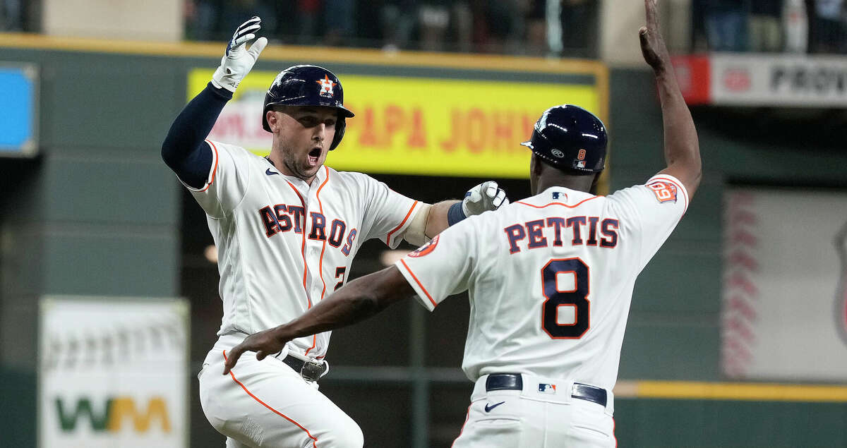 Houston Astros' Alex Bregman (2) high fives third base coach Gary Pettis (8) after hitting a two-run home run off of Seattle Mariners starting pitcher Logan Gilbert during the first inning of an MLB baseball game at Minute Maid Park on Thursday, July 28, 2022 in Houston .