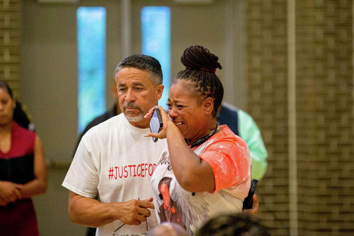 Tony Rachal, left, with his wife, Tiffany Rachal, mother of the late Jalen Randle, exits the meeting in tears during the town hall meeting for Jalen Randle at The Pleasantville Community Center, Thursday, July 28, 2022, in Houston.
