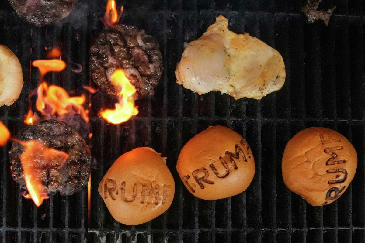 Burger patties, onions and buns branded with 'Trump' cook over the grill at Trump Burger Thursday, July 28, 2022 in Bellville, Texas.