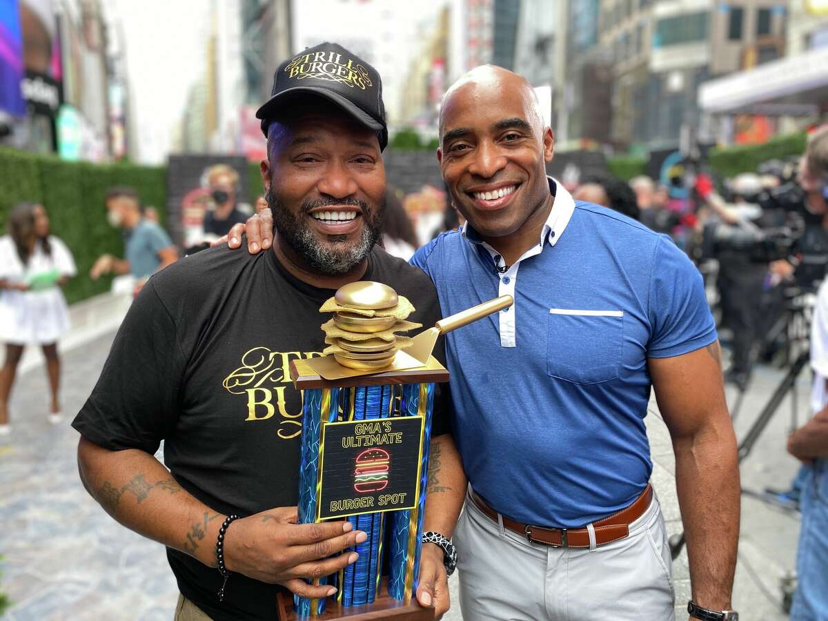 Bun B poses with NFL star Tiki Barber and a Golden Burger Trophy.