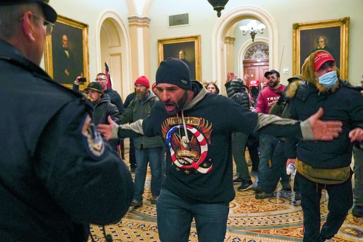 Trump supporters confront U.S. Capitol Police in the hallway outside of the Senate chamber during the Jan. 6, 2021, Capitol insurrection.