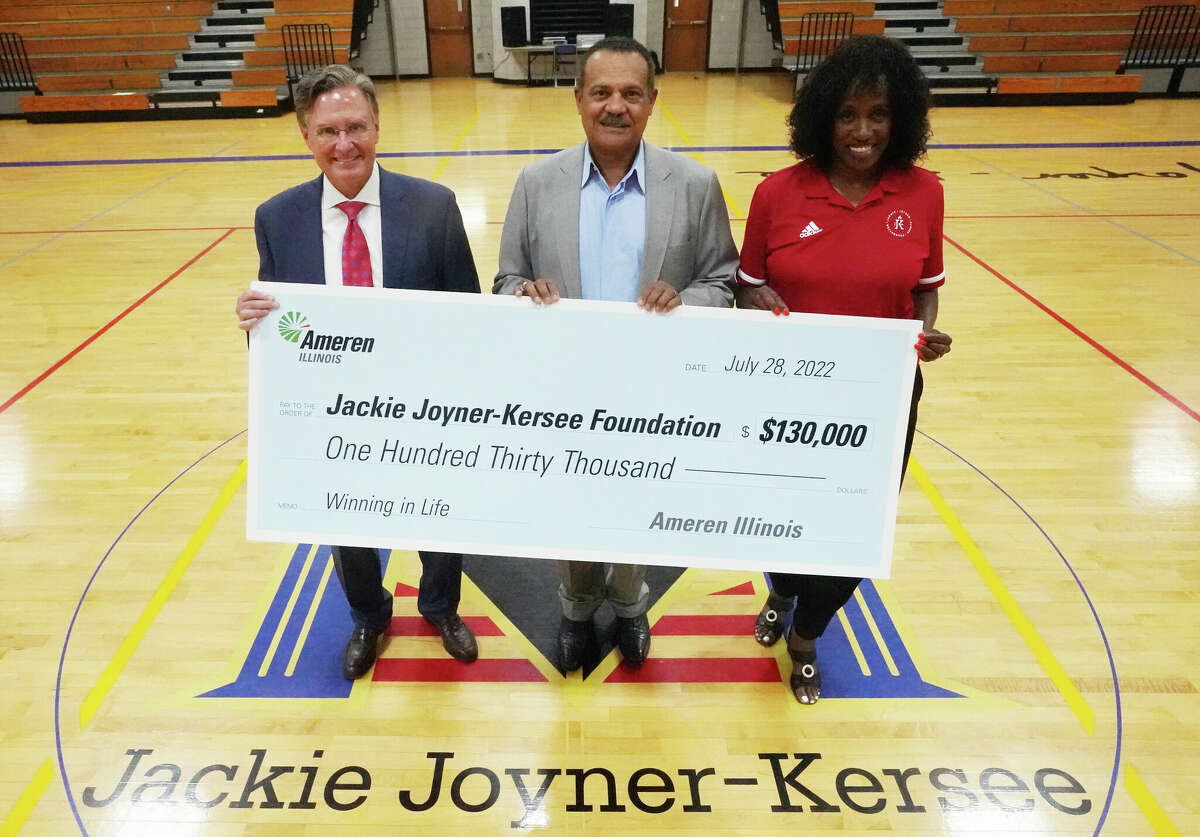 Marty Lyons, president and CEO of Ameren Corp., left; Richard Mark retiring president of Ameren Illinois, present Jackie Joyner-Kersee and her foundation with a check for $130,000 for the foundation's Winning in Life Initiative. Joyner-Kersee surprised Mark at the presentation when she announced the center's gym would be named the Richard Mark Gymnasium.