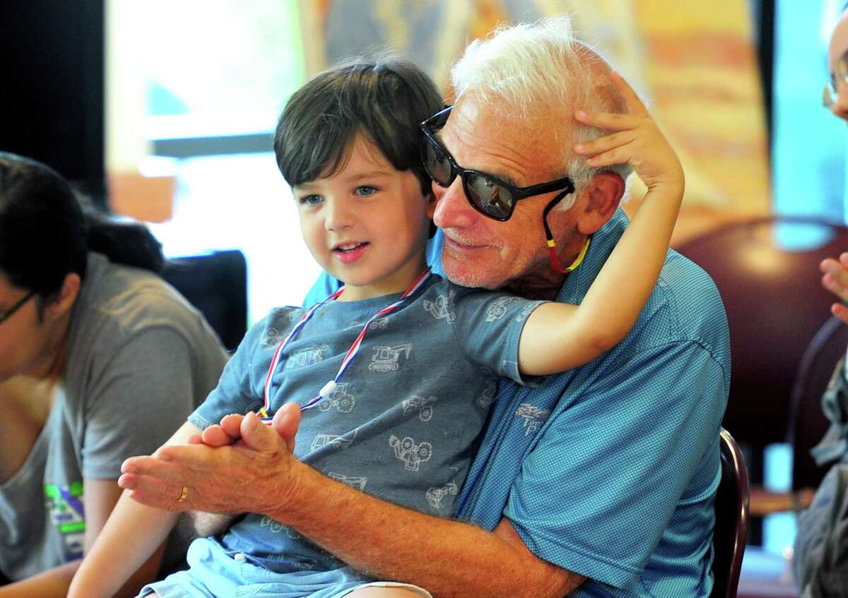 Bill Grad and his 4-year-old grandson Carter Field enjoy "Trip to a circus with Mr Rogers" a puppet show by puppeteer-in-residence, Robert Rogers, at the Byram Shubert Library in Greenwich, Connecticut on Thursday, July 28, 2022.