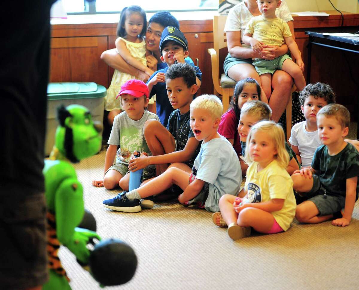 Jackson Hickey, 5, center, reacts the way he likes "Journey to a Circus with Mr Rogers," a puppet show by puppeteer-in-residence, Robert Rogers, at the Byram Shubert Library in Greenwich, Connecticut on Thursday, July 28, 2022.