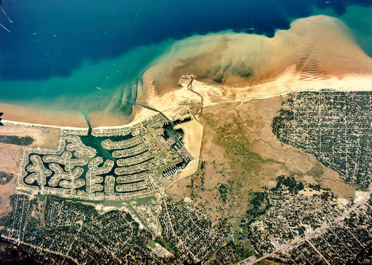 An aerial photo of the Tahoe Keys and the Upper Truckee River Marsh before restoration efforts began. The Tahoe Keys development carved up half of the marsh and dried up the rest, sending plumes of sediment into Lake Tahoe.