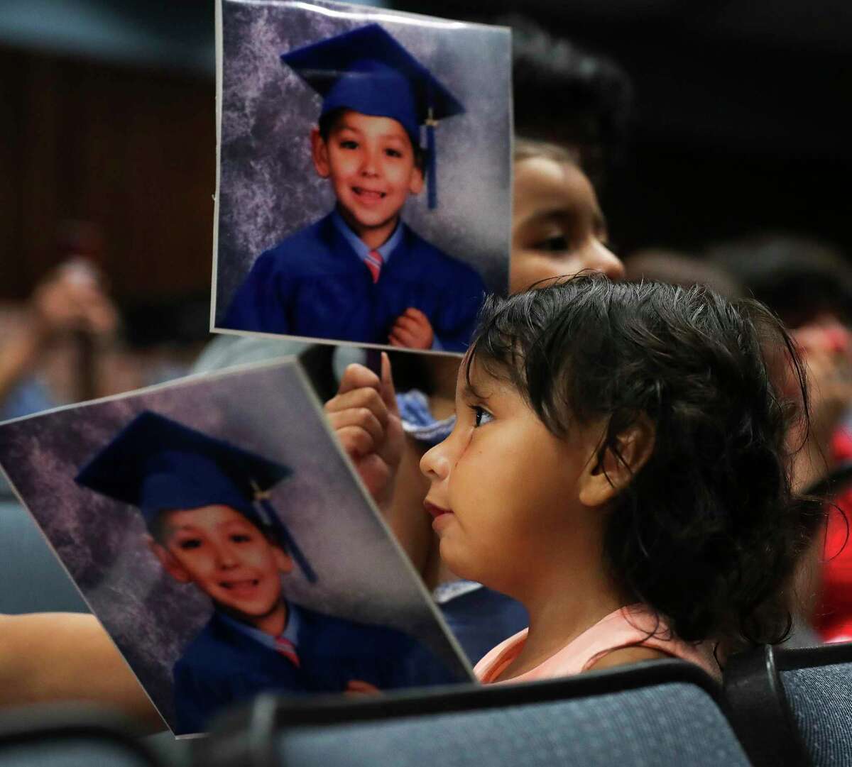 Jailyn Aguillar hold a kindergarten photo of her uncle, Ismael Salas, along with other family members during a summer graduation ceremony for Conroe ISD students at College Park High School, Thursday, July 28, 2022, in The Woodlands. Nearly 50 senior student from across Conroe ISD received their high school diplomas.