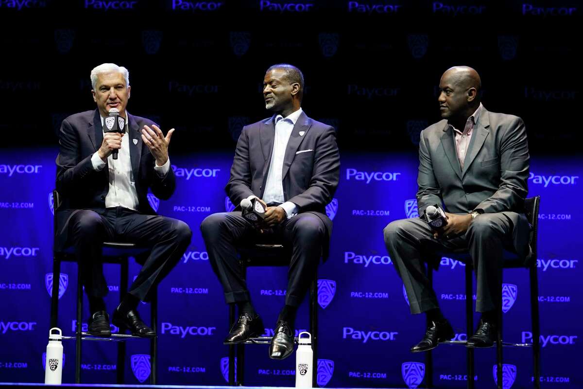 George Kliavkoff, Commissioner of the Pac-12 Conference, left, with Senior Associate Commissioner Merton Hanks, center, and Stanford Athletic Director Bernard Muir take questions from the media during opening of the Pac-12 NCAA college football media day Friday, July 29, 2022, in Los Angeles. (AP Photo/Damian Dovarganes)
