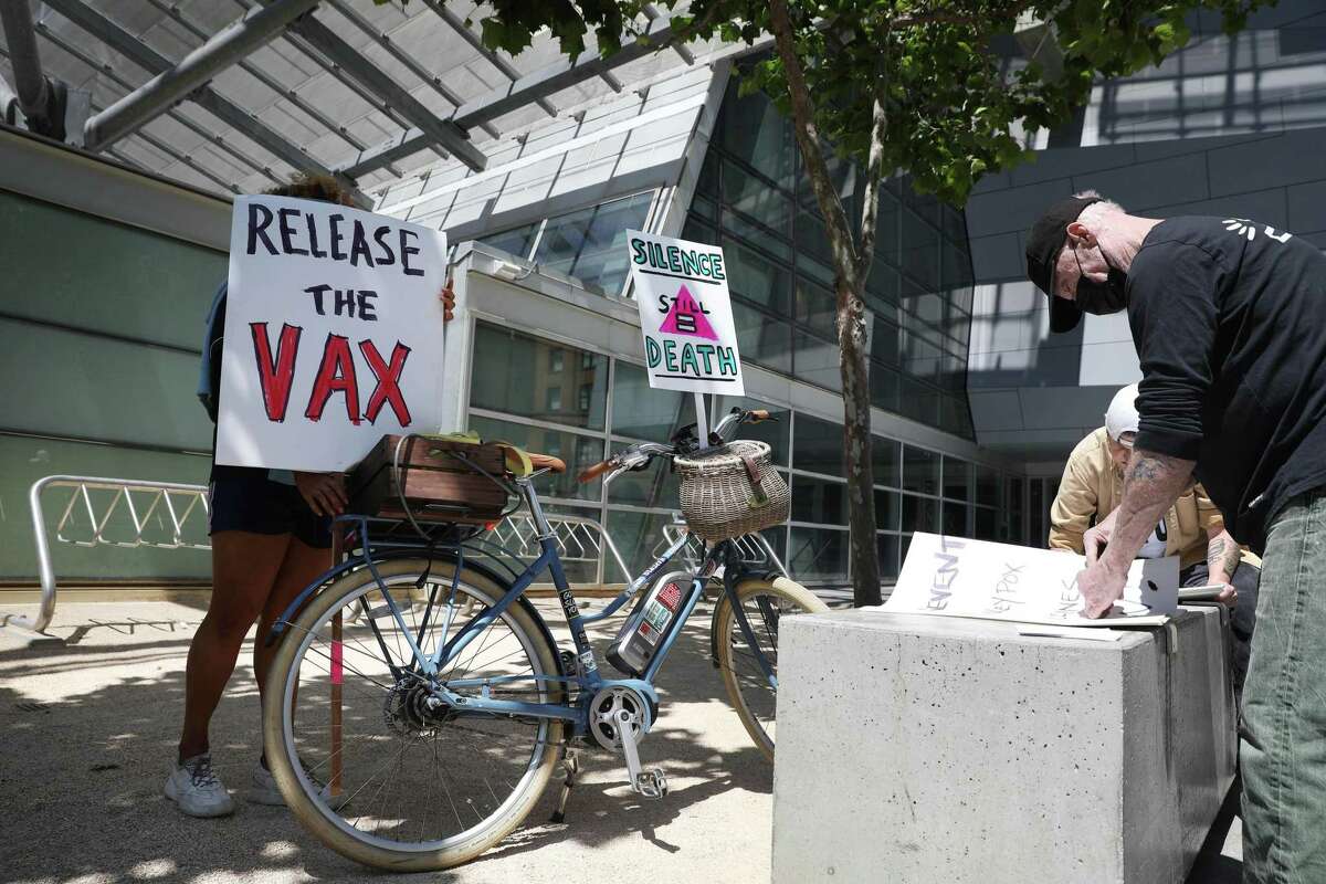 奥克兰的马修·夏普(右)是艾滋病长期幸存者，也是艾滋病倡导网络的成员，旧金山的埃内斯托·奎利拉(左)是Alice B. Toklas LGBTQ民主俱乐部和Harvey Milk LGBTQ民主俱乐部的成员，2022年7月18日，他们在旧金山联邦大楼外示威前准备标语，要求美国卫生与公众服务部增加猴痘疫苗的分发。