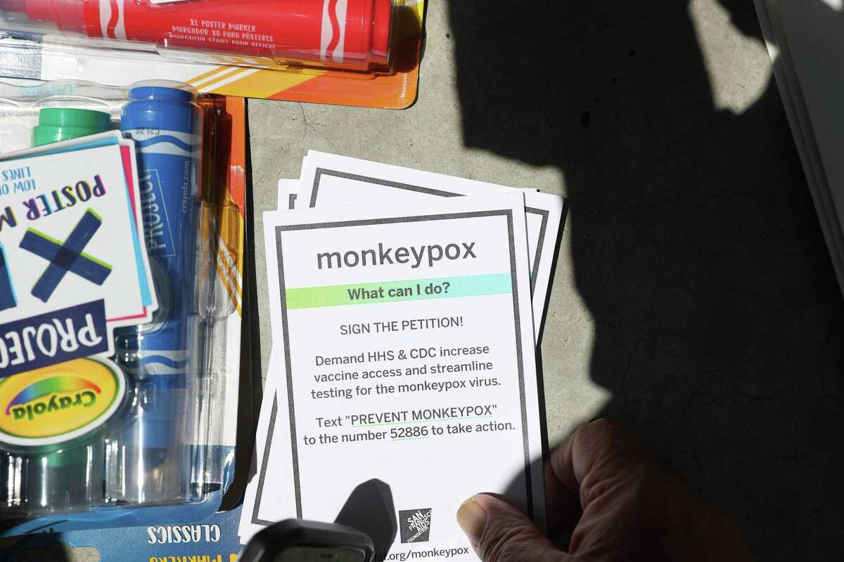 2022年7月18日，加利福尼亚州旧金山，一名示威者手持一叠卡片，人们在旧金山联邦大楼外抗议，要求美国卫生与公众服务部加快猴痘疫苗的分发。