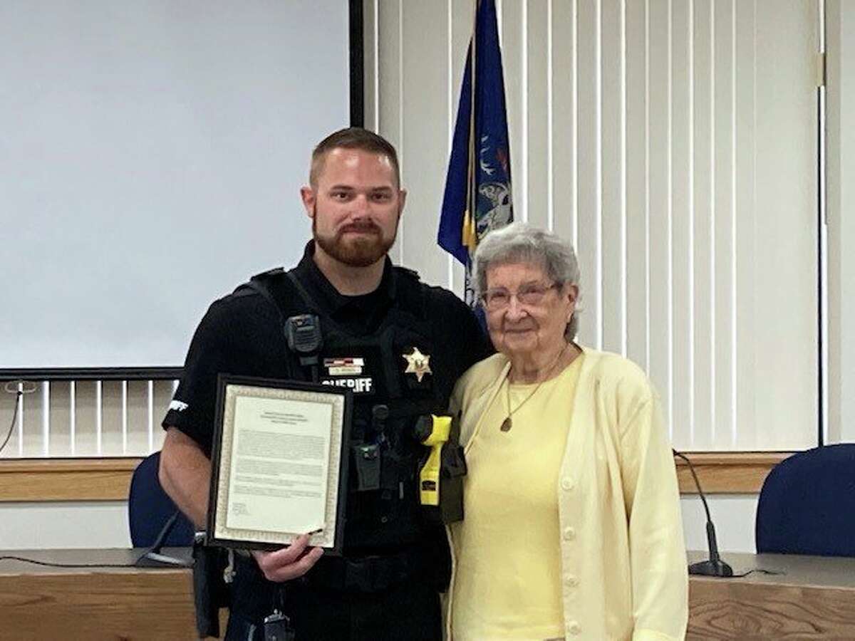 Dillon Rosa, animal control officer for Manistee County, with Blanche Blacklock, who he pulled from her car after she hit a gas main with her vehicle. Rosa was awarded the Bravery and Lifesaving Award for his actions.  