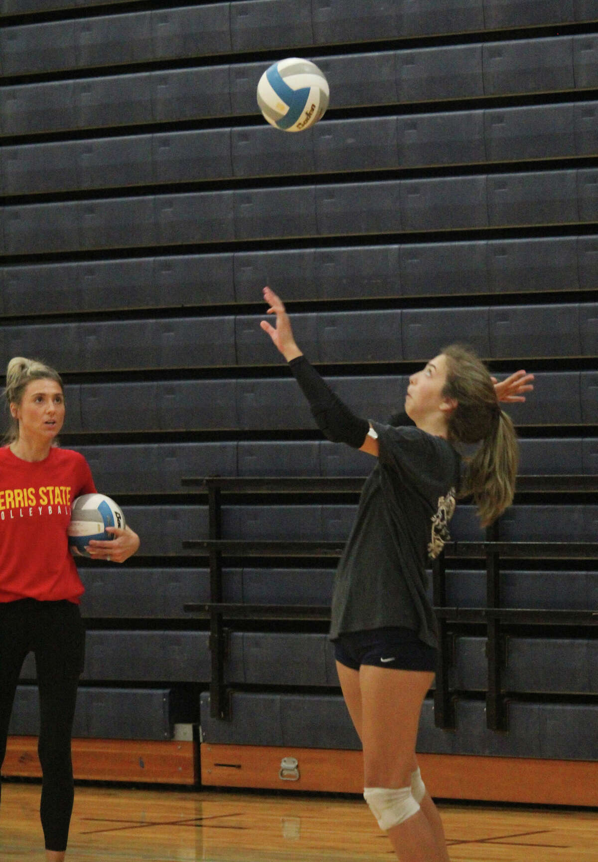 Ferris State assistant volleyball coach Hannah (Nimrick) Wuest watches as Big Rapids' Kate Strasser serves the ball on Thursday during a Cardinal volleyball camp.