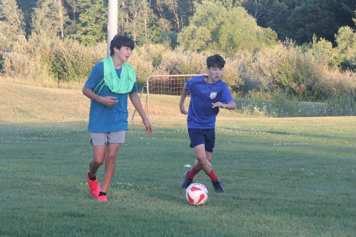 Big Rapids soccer players Matt Spedowski (left) and Welsey Heydens go after the ball during a drop-in soccer session at BRHS on Thursday.