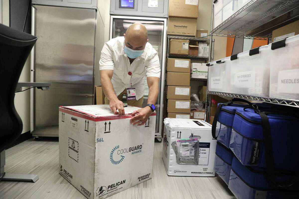 在旧金山总医院，药剂师乔纳森·帕杜乔打开装有猴痘Jynneos疫苗的冷冻运输箱。