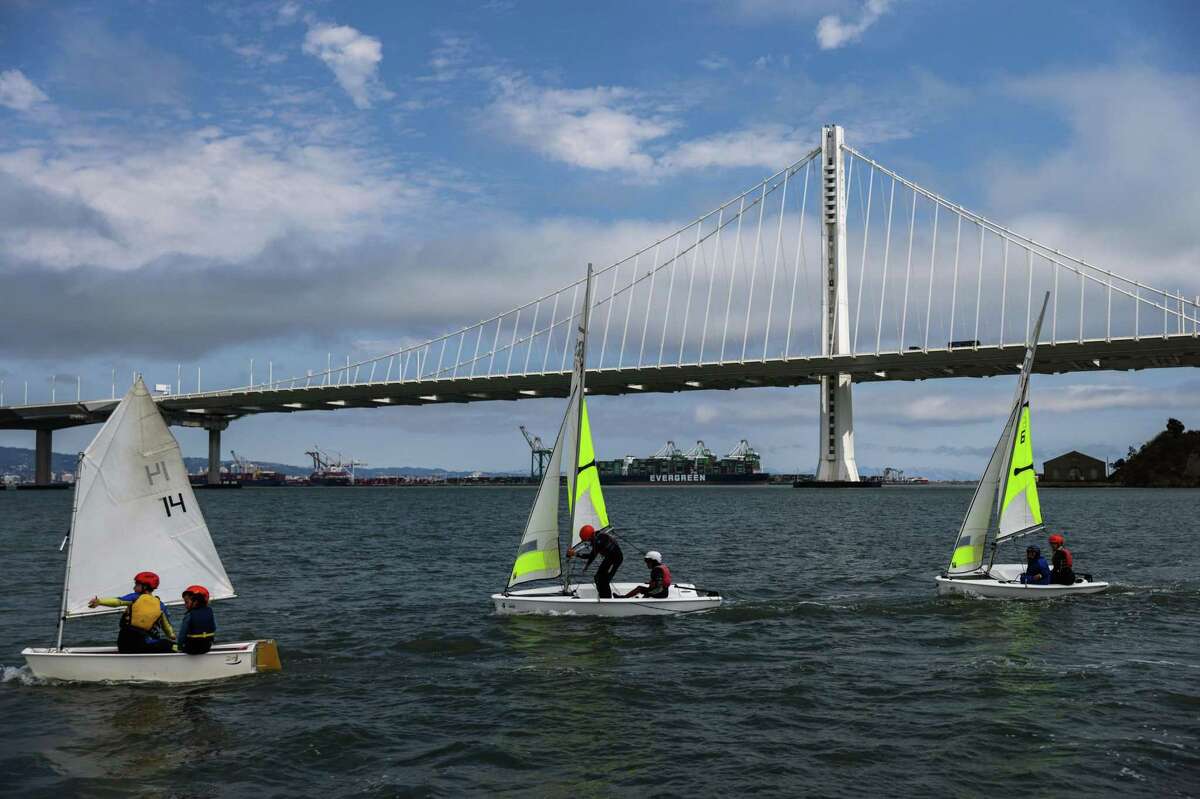 年轻的学生在金银岛帆船中心附近的海湾里学习帆船。旧金山正在考虑对金银岛征收通行费，这将禁止一些学生上课。