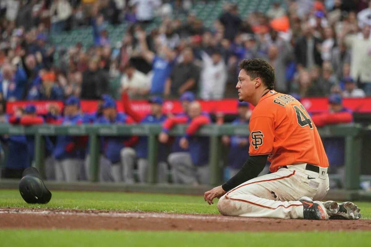San Francisco Giants' Wilmer Flores pauses after being tagged out at home by Chicago Cubs catcher Willson Contreras during the first inning of a baseball game in San Francisco, Friday, July 29, 2022. (AP Photo/Godofredo A. Vásquez)