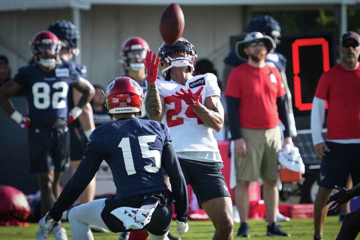 Houston Texans defensive back Derek Stingley Jr., (24) feels a punt as wide receiver Chris Moore (15) runs in to make the play during an NFL training camp Saturday, July 30, 2022, in Houston.