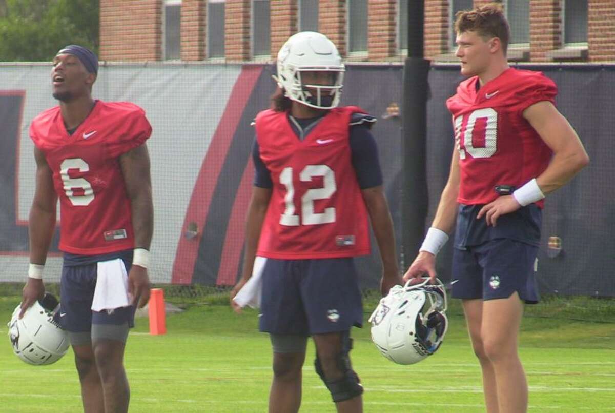 UConn quarterbacks Ta’Quan Roberson (6), Tyler Phommachanh (12) and Cale Millen (10) look on during a July 29 practice in Storrs.
