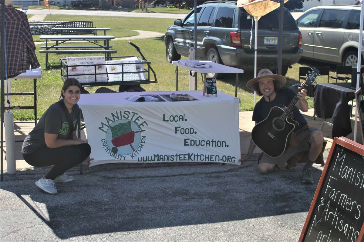 Kylie Davis (left), Manistee Farmers Market food navigator, and Brian Garcia, market manager, pose for a photo Saturday during the farmers market in Manistee.