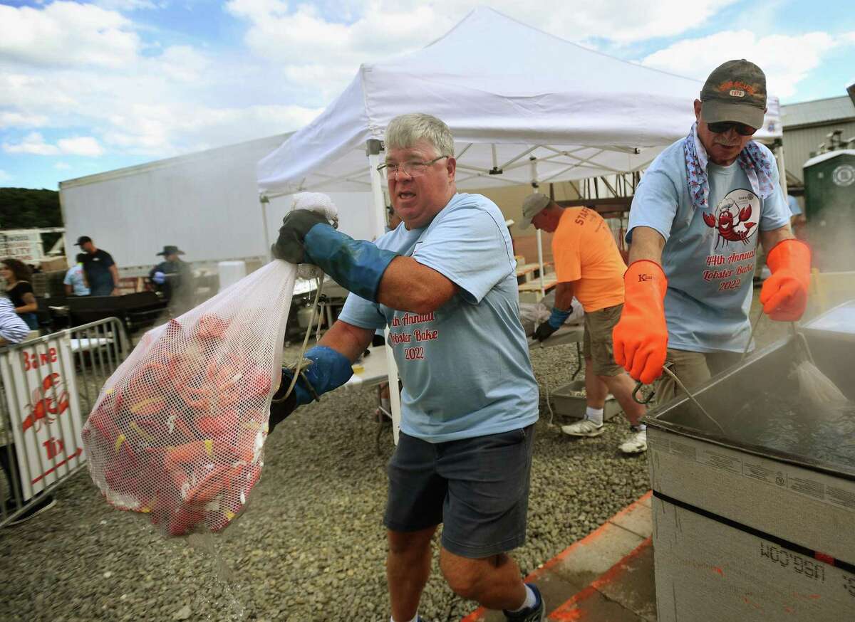 Rotary members Greg Schmitt, left, and Phil Caporusso cook bags of lobsters at the annual Milford Rotary Lobster Bake at Lisman Landing in Milford, Conn. on Saturday, July 30, 2022.