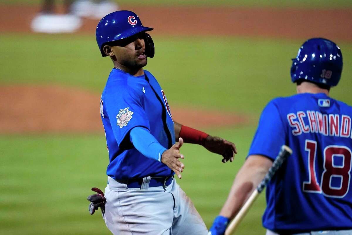 Chicago Cubs' Dixon Machado, left, celebrates with Frank Schwindel (18) after Machado scored against the San Francisco Giants during the third inning of a spring training baseball game Friday, March 18, 2022, in Scottsdale, Ariz. (AP Photo/Ross D. Franklin)