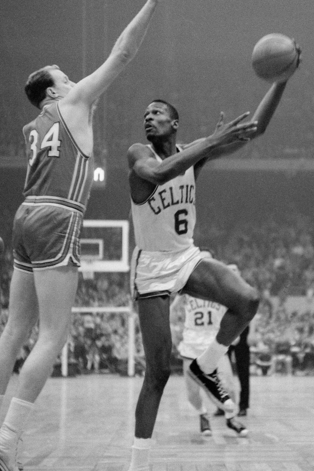 The Celtics’ Bill Russell attempts a hook shot in the championship final in 1960 against the St. Louis Hawks. He scored 35 points in Game 7 as Boston triumphed 122-103 for their 3rd title.