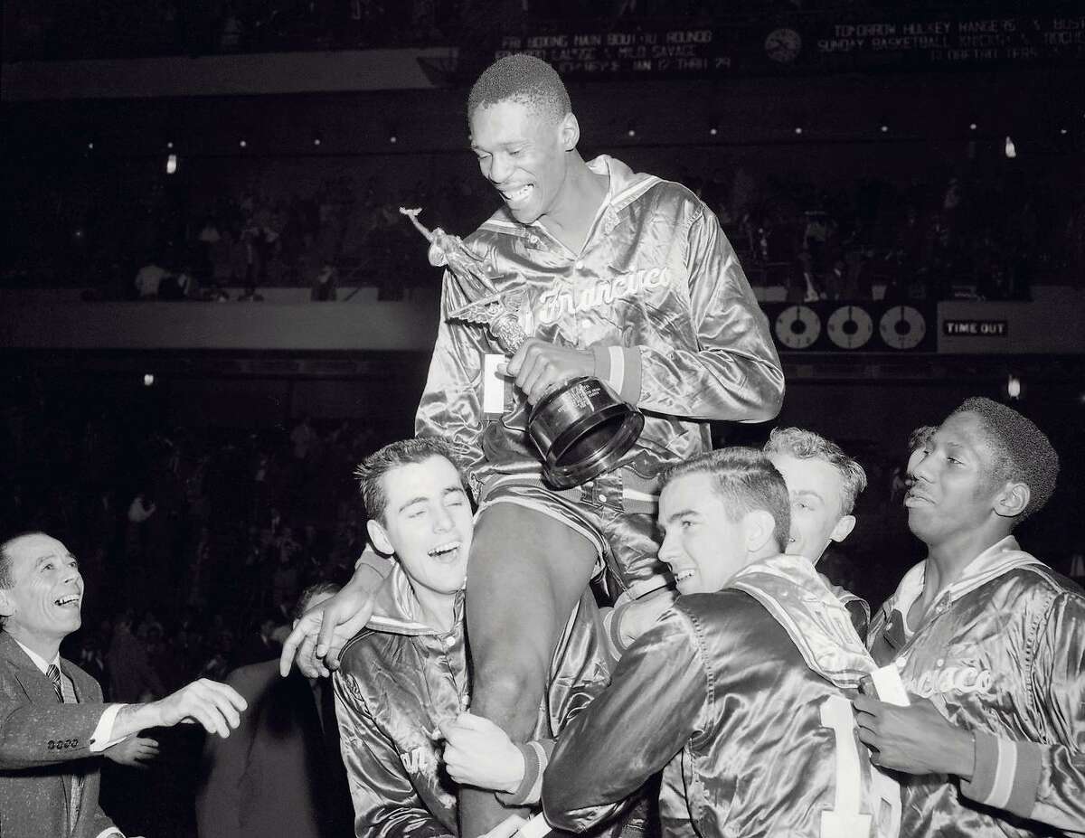 USF teammates raise 6-foot-10 center Bill Russell onto their shoulders after a big victory. in a