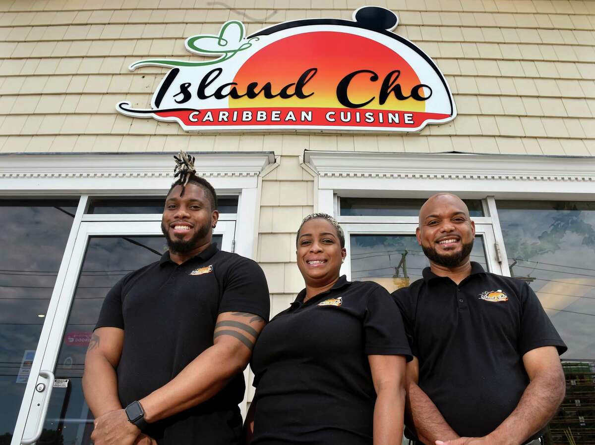 From left, co-owners Omari Wright, his aunt, Gillian Webb, and uncle, Charlton Webb, are photographed in front of their new Caribbean restaurant, Island Cho, on Washington Avenue in North Haven.