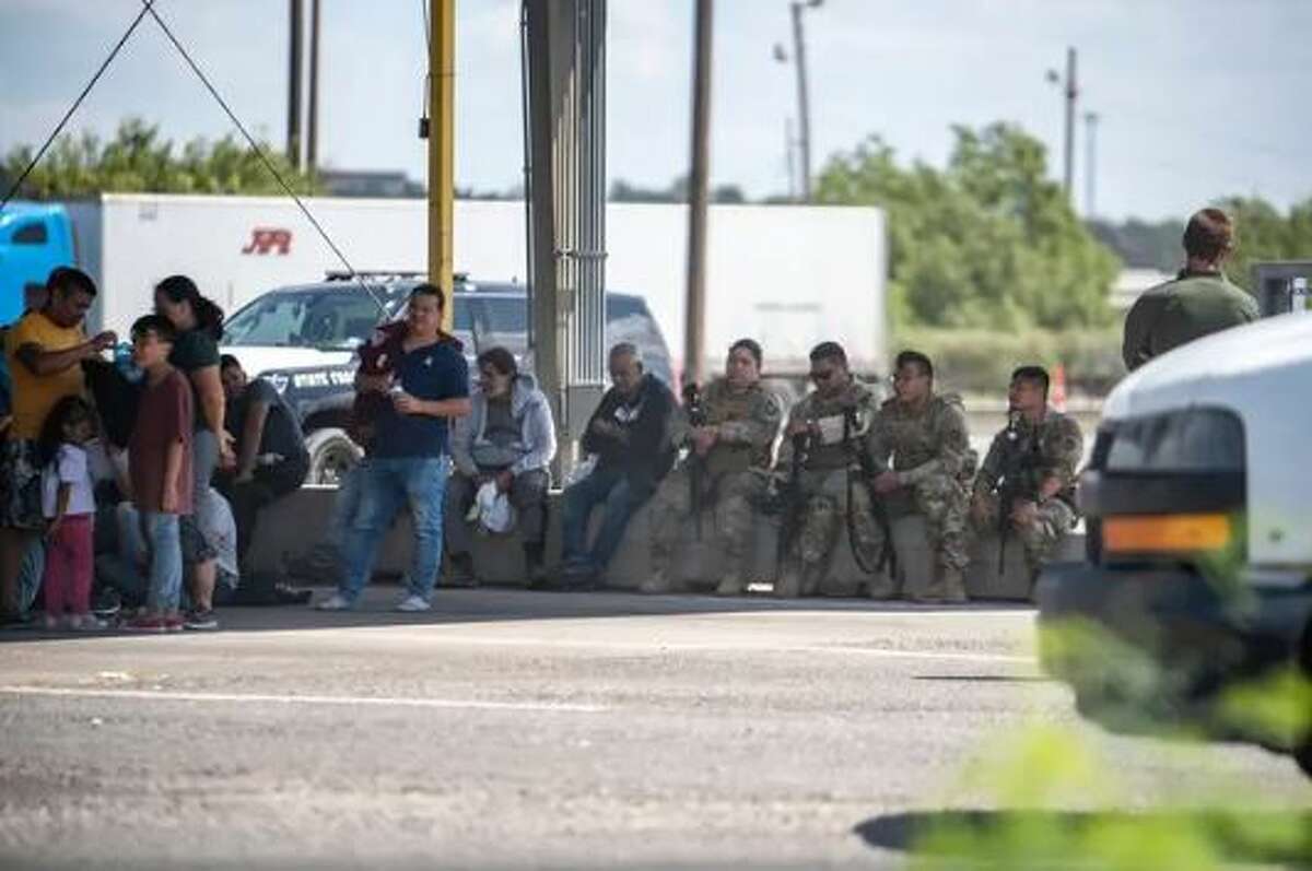 People who were apprehended by state troopers after crossing the border are brought to the International Bridge in Eagle Pass on May 28 to be handed over to Border Patrol custody. Credit: Sergio Flores for The Texas Tribune