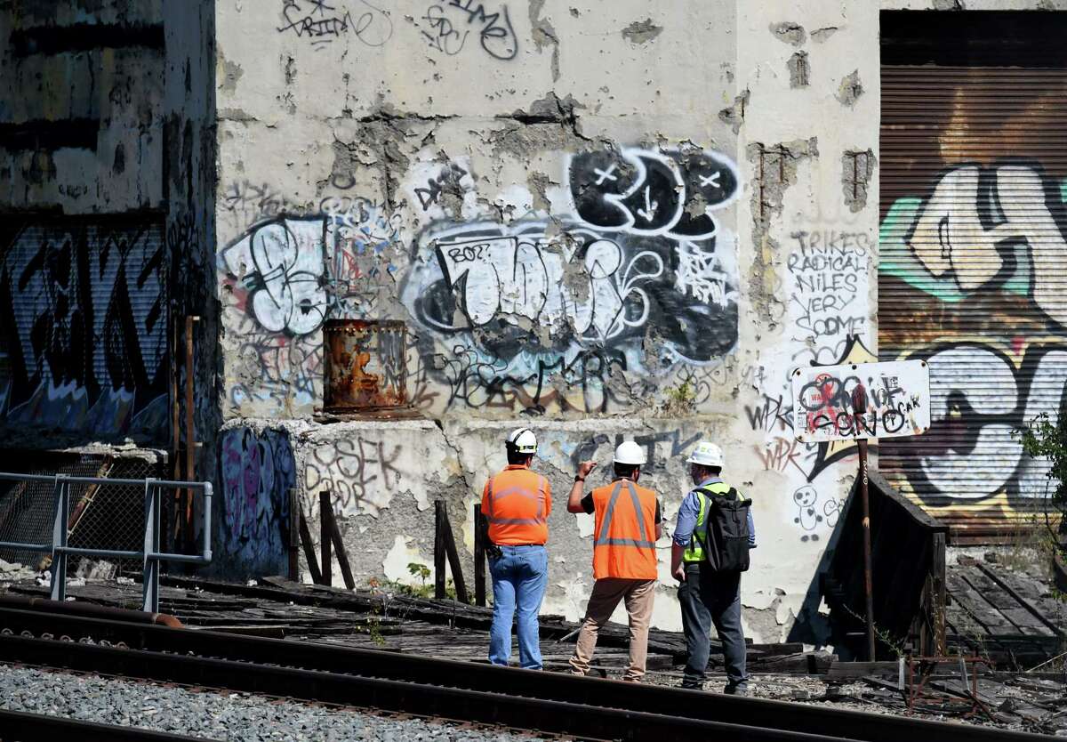 Inspectors survey damage to Central Warehouse from the nearby train tracks on Monday Aug. 1, 2022, in Albany, N.Y. Amtrak postponed travel through Albany due to safety concerns over the structural integrity of Central Warehouse, which sits close to railroad tracks.