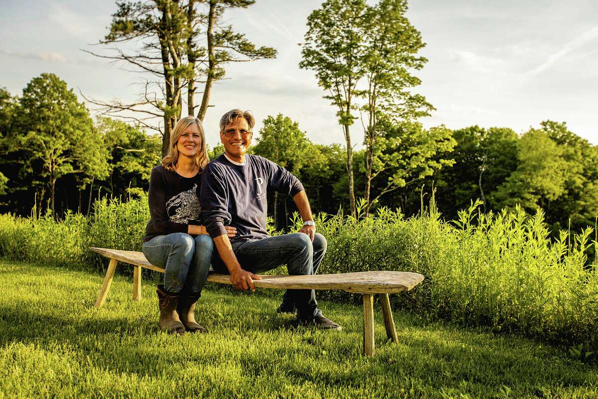 Lynn and Oscar sit on the hill that overlooks their sanctuary property.
