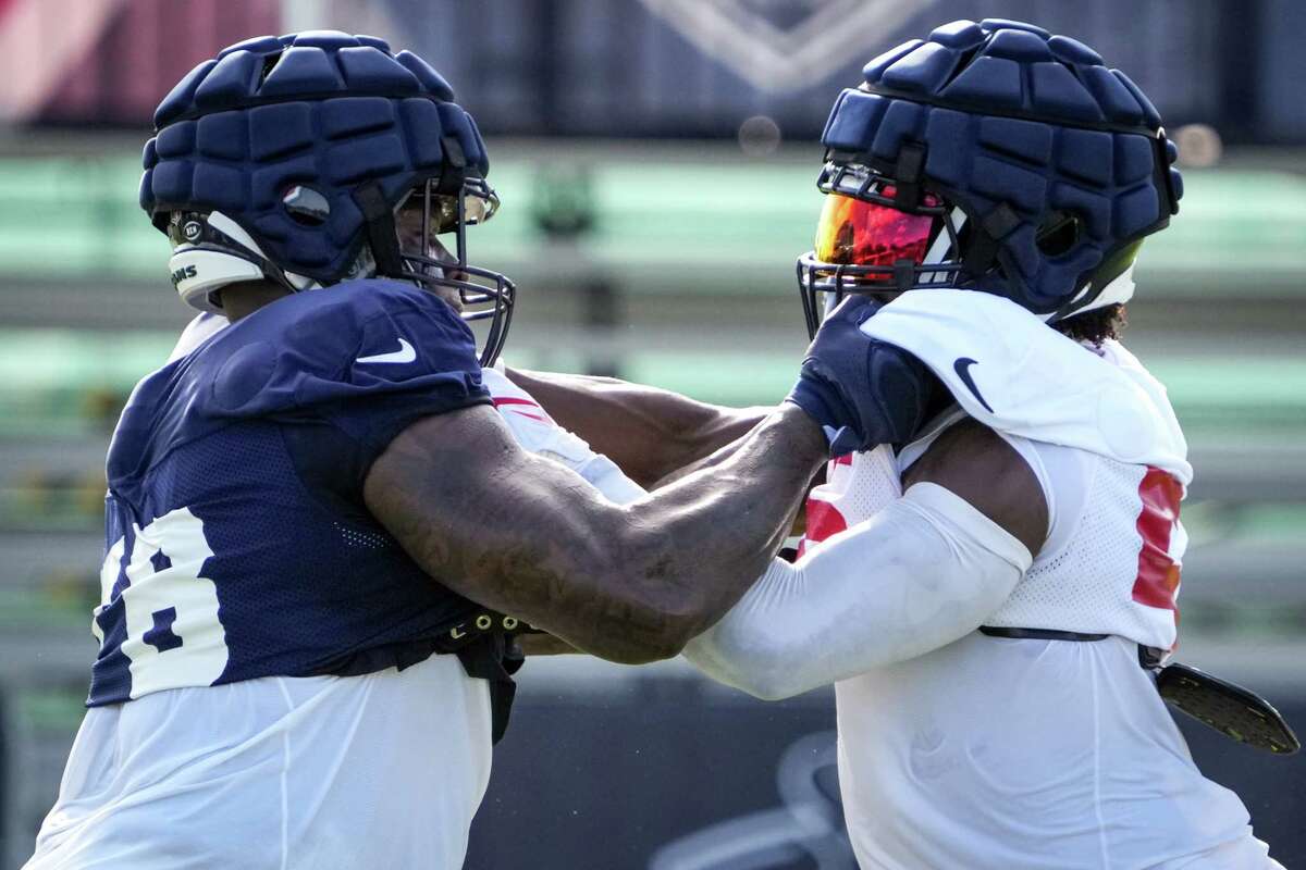 Houston Texans tackle Laremy Tunsil (78) and defensive lineman Jerry Hughes (55) work against each other during an NFL training camp Monday, Aug. 1, 2022, in Houston.