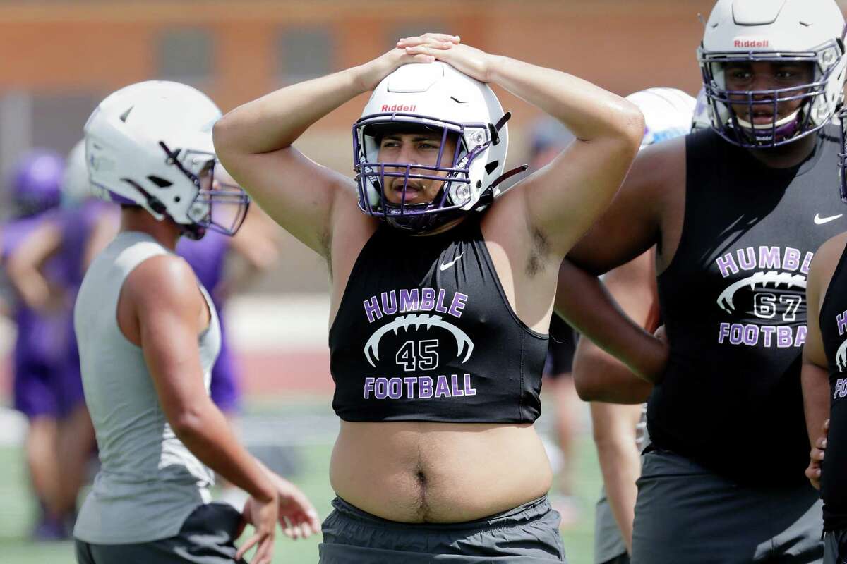 Defender Isaiah Quezada, center, takes a break between drills during the first football practice of the year at Turner Stadium at Humble High School Monday, Aug. 1, 2022 in Humble, TX.