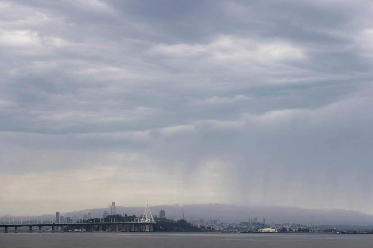 2022年8月1日星期一，从加利福尼亚州埃默里维尔的埃默里维尔码头的海滨看到，巨大的黑色风暴云徘徊在旧金山上空。
