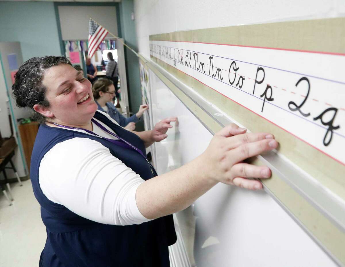 Casey Colley puts up an alphabet strip as teachers and staff prepare for the upcoming school year at Turner Elementary School, Friday, July 29, 2022, in Willis.