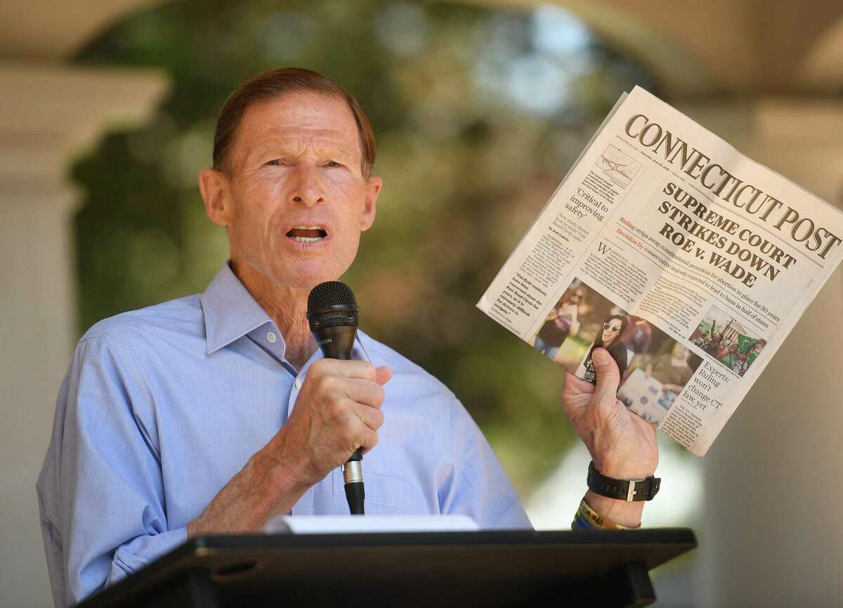 Senator Richard Blumenthal holds up a copy of Saturday's Connecticut Post, one of many items to be placed in a fifty year time capsule during the 100th anniversary celebration at the Beardsley Zoo in Bridgeport, Conn. on Saturday, June 25, 2022.