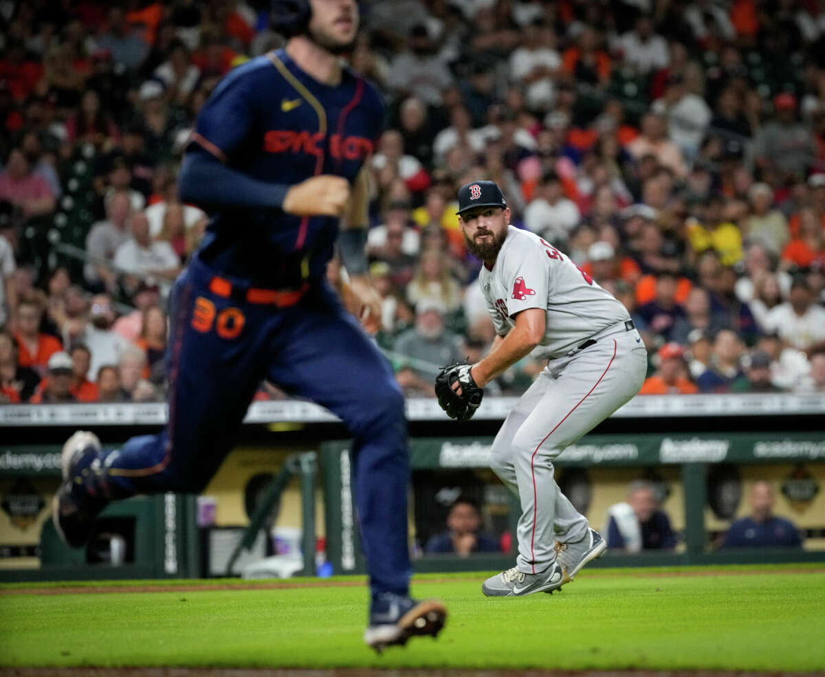 Boston Red Sox relief pitcher John Schreiber (46) prepares to throw first baseman Bobby Dalbec (29) to get out Houston Astros right fielder Kyle Tucker (30) at first during the eighth inning of an MLB game Monday, Aug. 1, 2022, at Minute Maid Park in Houston.