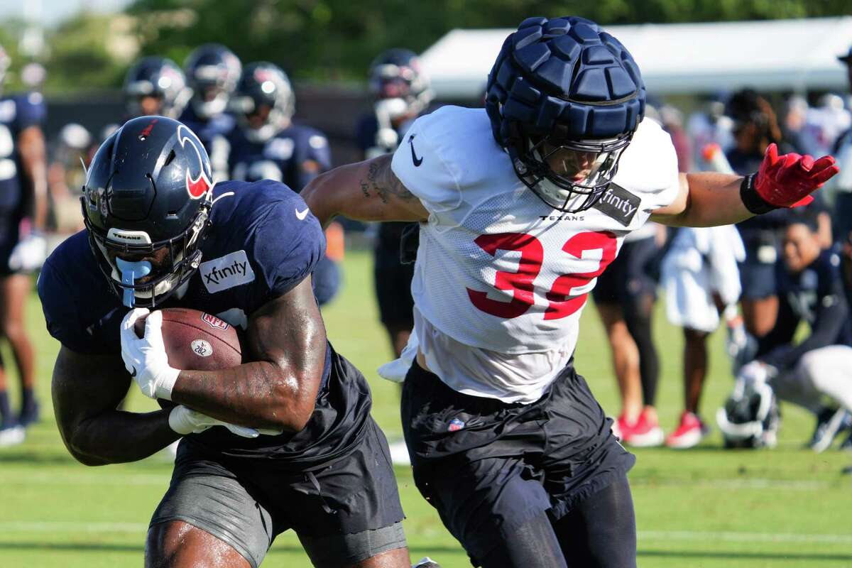 Houston Texans running back Royce Freeman, left, makes a catch against linebacker Garret Wallow (32) during an NFL training camp Tuesday, Aug. 2, 2022, in Houston.