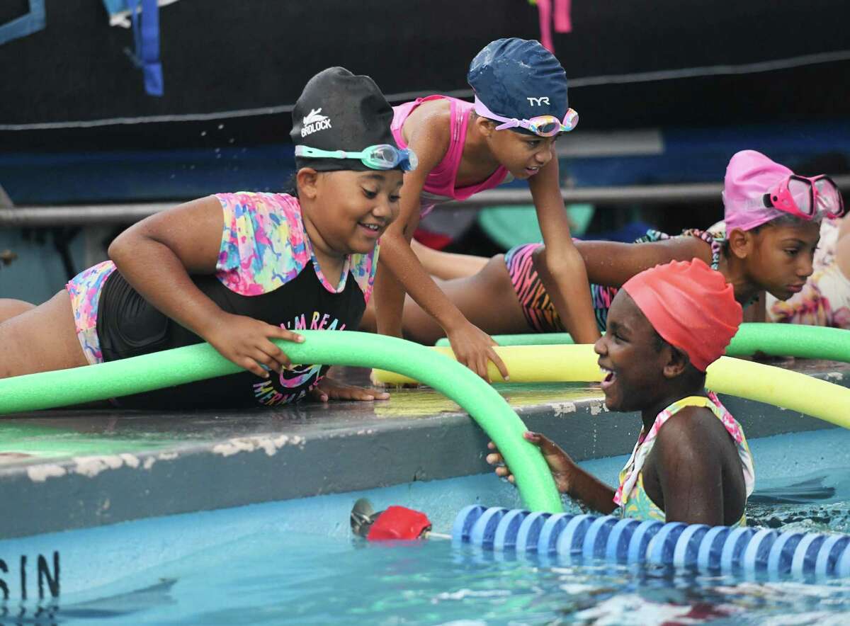 May'lani Gary, left, and Michelah Lawrence practice a poolside rescue technique at the ZAC Foundation swim camp at the Boys & Girls Club Yerwood Center in Stamford, Conn. Tuesday, Aug. 2, 2022. 120 kids ages five through nine are attending the 4-day camp, which teaches valuable information to keep them safe in the water. The camp uses classroom activities, in-water swimming instruction, and first responder interaction to teach essential swim safety lessons. The ZAC Foundation was established in 2008 by Karen and Brian Cohn after losing their 6-year-old son, Zachary Archer Cohn, in a swimming accident in their backyard pool.