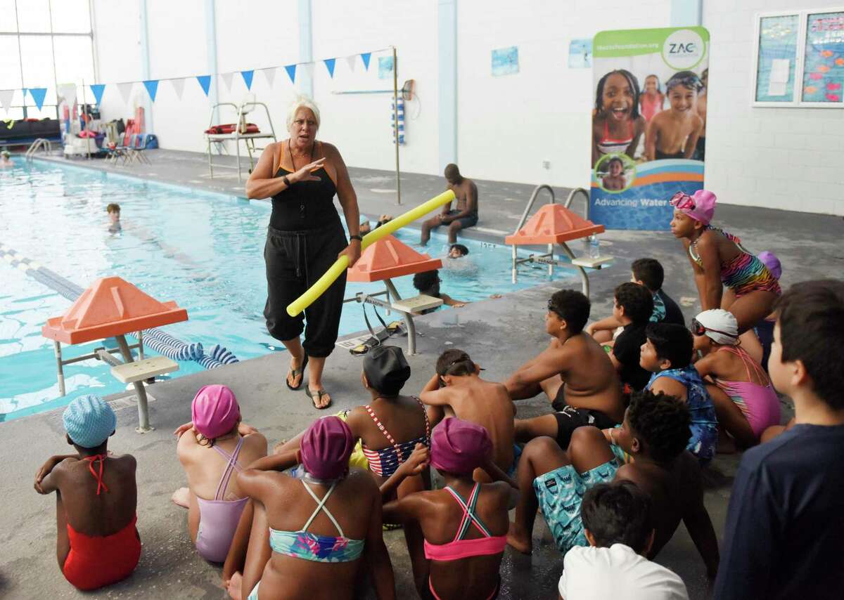 Instructor Dawn Berrocal leads a swim lesson at the ZAC Foundation swim camp at the Boys & Girls Club Yerwood Center in Stamford, Conn. Tuesday, Aug. 2, 2022. 120 kids ages five through nine are attending the 4-day camp, which teaches valuable information to keep them safe in the water. The camp uses classroom activities, in-water swimming instruction, and first responder interaction to teach essential swim safety lessons. The ZAC Foundation was established in 2008 by Karen and Brian Cohn after losing their 6-year-old son, Zachary Archer Cohn, in a swimming accident in their backyard pool.