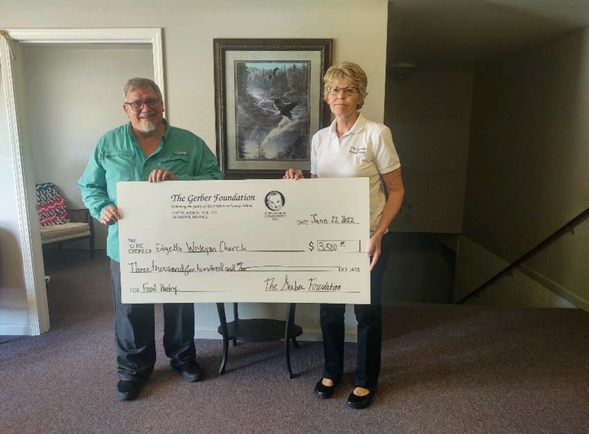 Pastor Dan Miller of Edgetts Wesleyan Church in Luther accepts a donation check for $3,500 from the Gerber Foundation on behalf of the Handfuls of Purpose Community Food Pantry.