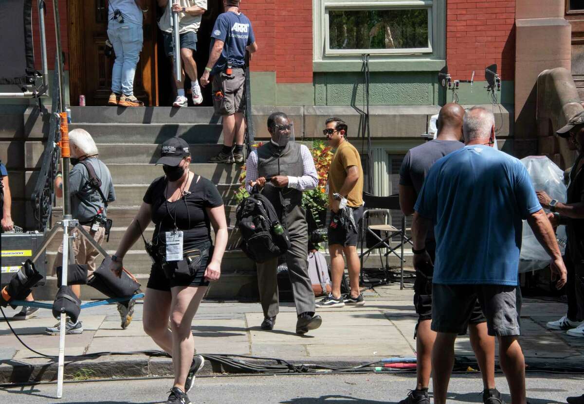 Actor John Douglas Thompson, center with face shield, is seen walking out of a building on 3rd St. during the filming of HBO series “Gilded Age” on Tuesday, Aug. 2, 2022 in Troy, N.Y.
