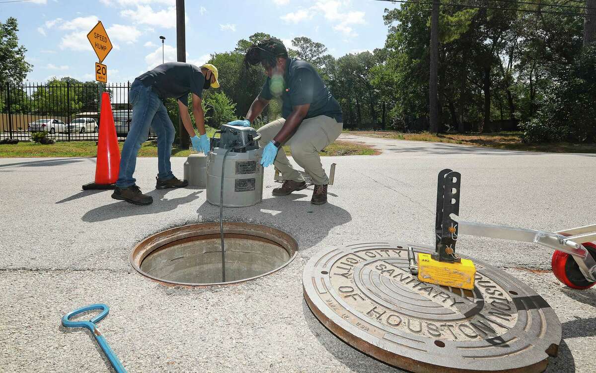 Houston Health Dept., employees Muhammad Farhad, left, and Kendra Davis prepare to put back the sampler after collecting water samples on Wednesday, July 20, 2022 in Houston. 