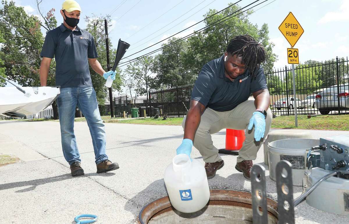 Houston Health Dept., employees Muhammad Farhad, left, and Kendra Davis prepare to collect water samples on Wednesday, July 20, 2022 in Houston. Houston was one of the first cities in the nation to post wastewater data to forecast COVID infection trends. It has been a consistently reliable indicator throughout the pandemic.