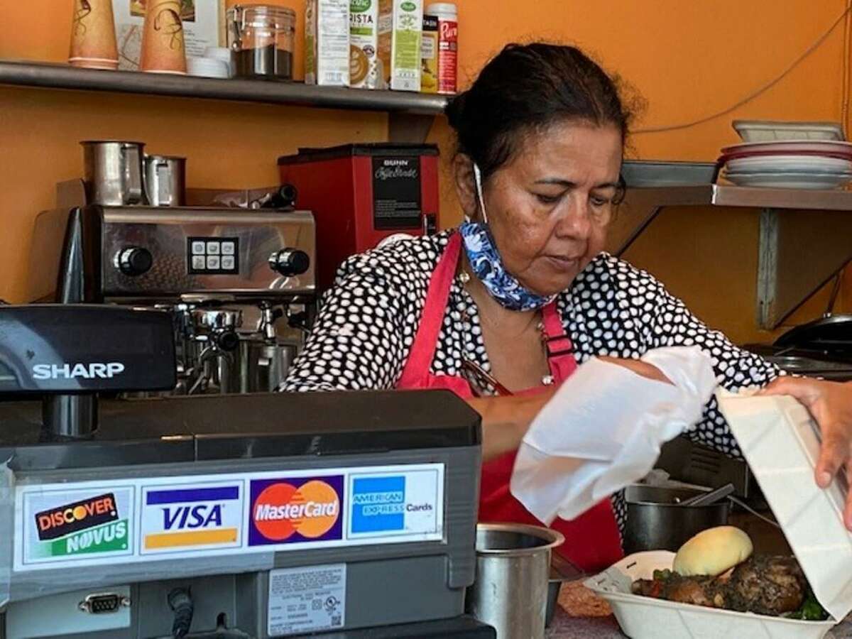 在奥克兰市中心经营一家咖啡馆的最后日子里，阿努拉·艾迪辛哈(Anula ediinghe)在为顾客服务。