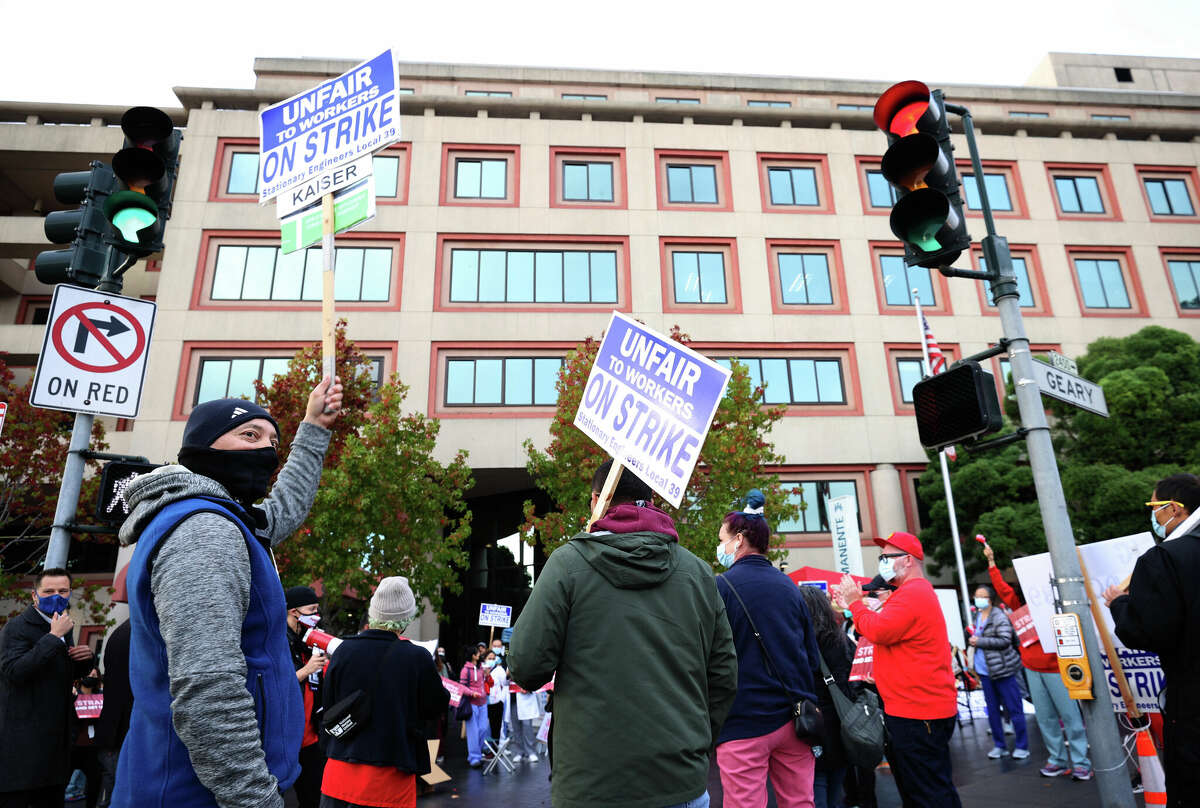 Kaiser Permanente union workers hold on strike signs during an informational picket outside of the Kaiser Permanente San Francisco Medical Center on Nov. 10, 2021, in San Francisco. Kaiser Permanente therapists are holding an indefinite strike starting Aug. 15.