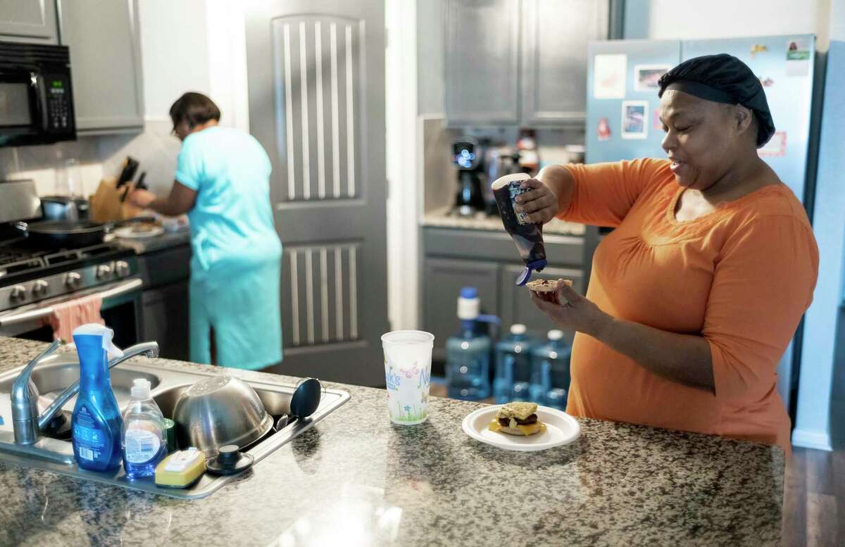 Homeowner, Enrika Goins, and her mother, Pamela Andrews, right, enjoy breakfast on July 30, 2022, in Hutto, Texas, in their new home.