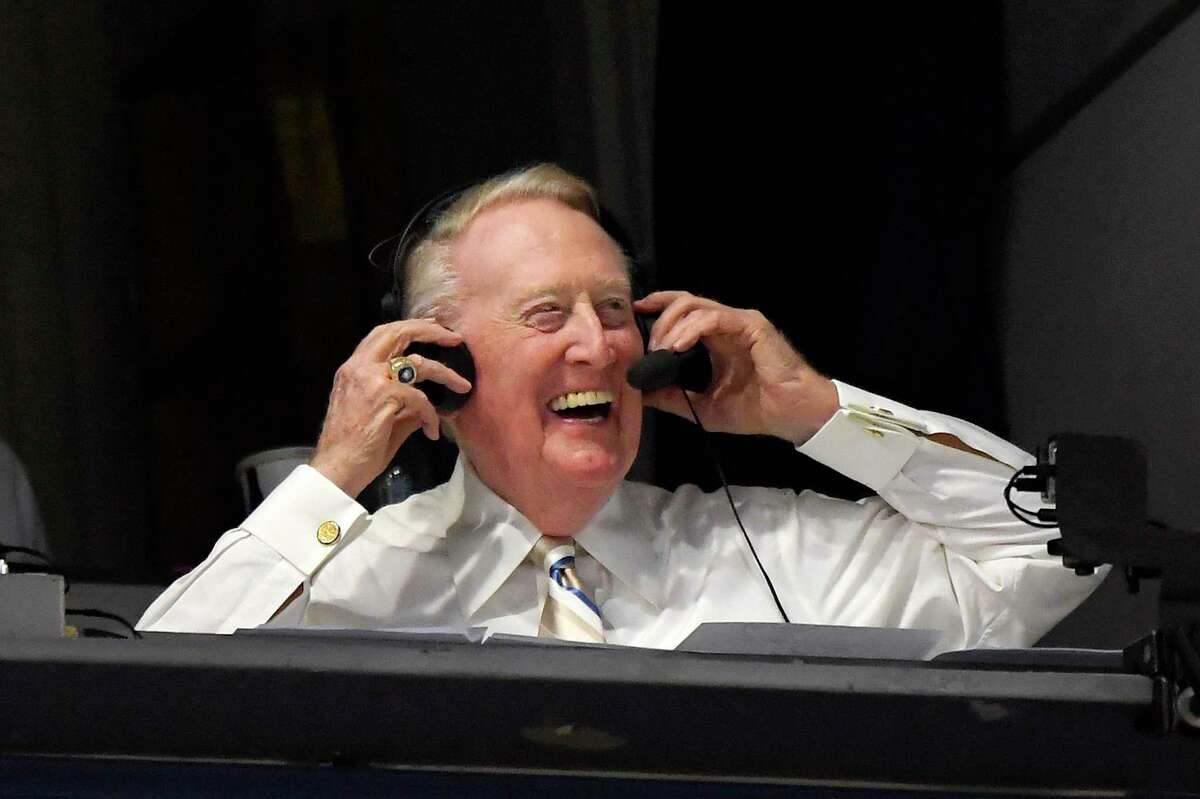 FILE - In this Sept. 19, 2016, file photo, Los Angeles Dodgers Hall of Fame announcer Vin Scully puts his headset on prior to a baseball game between the Dodgers and the San Francisco Giants in Los Angeles. Scully has culled items from his personal collection of memorabilia for auction on Sept. 23. (AP Photo/Mark J. Terrill, File)