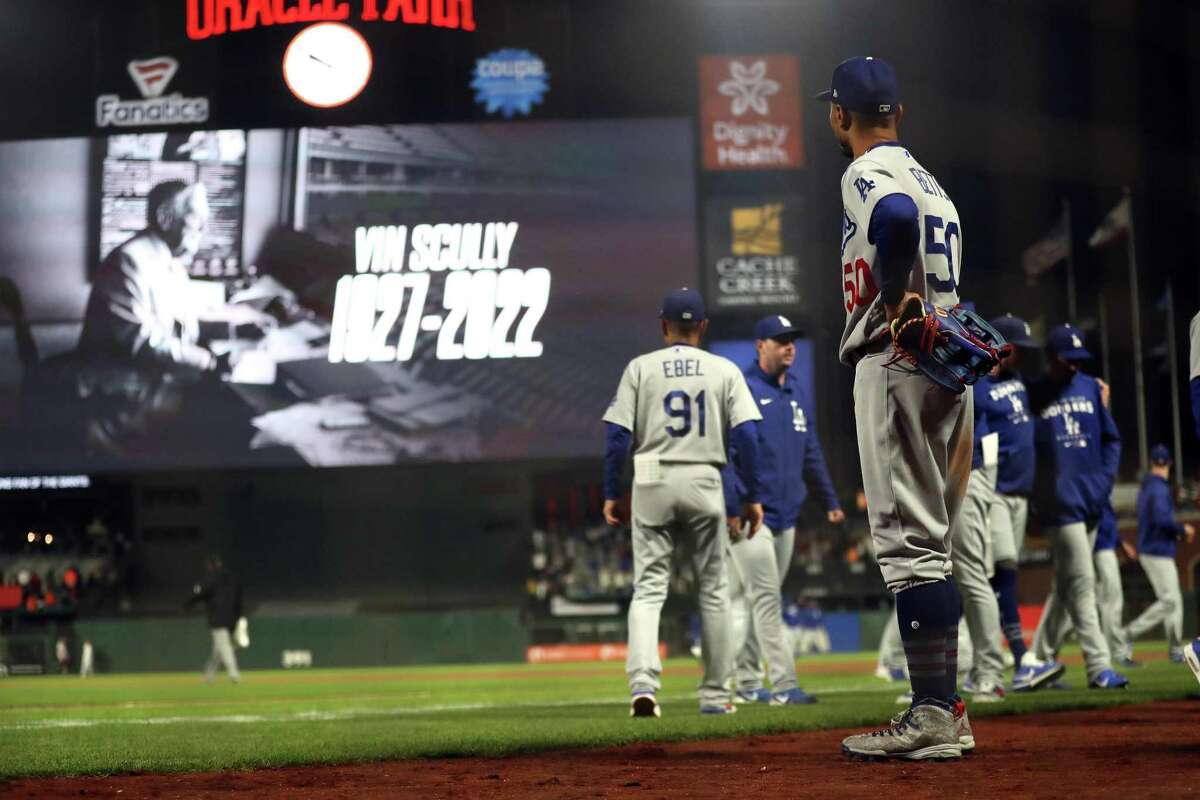 Los Angeles Dodgers’ Mookie Betts looks at the Oracle Park scoreboard as the news of Vin Scully’s death is announced after Dodgers’ 9-5 win over San Francisco Giants.