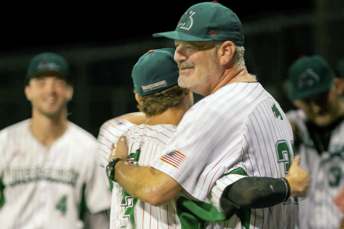 Alton River Dragons manager Darrell Handelsman gets a hug from outfielder Mike Hampton after his 750th managerial victory Aug. 2 in a win over Quincy at Lloyd Hopkins Field. Handelsman has resigned as Dragons manager to accept a position with a team closer to his home and family in Minnesota